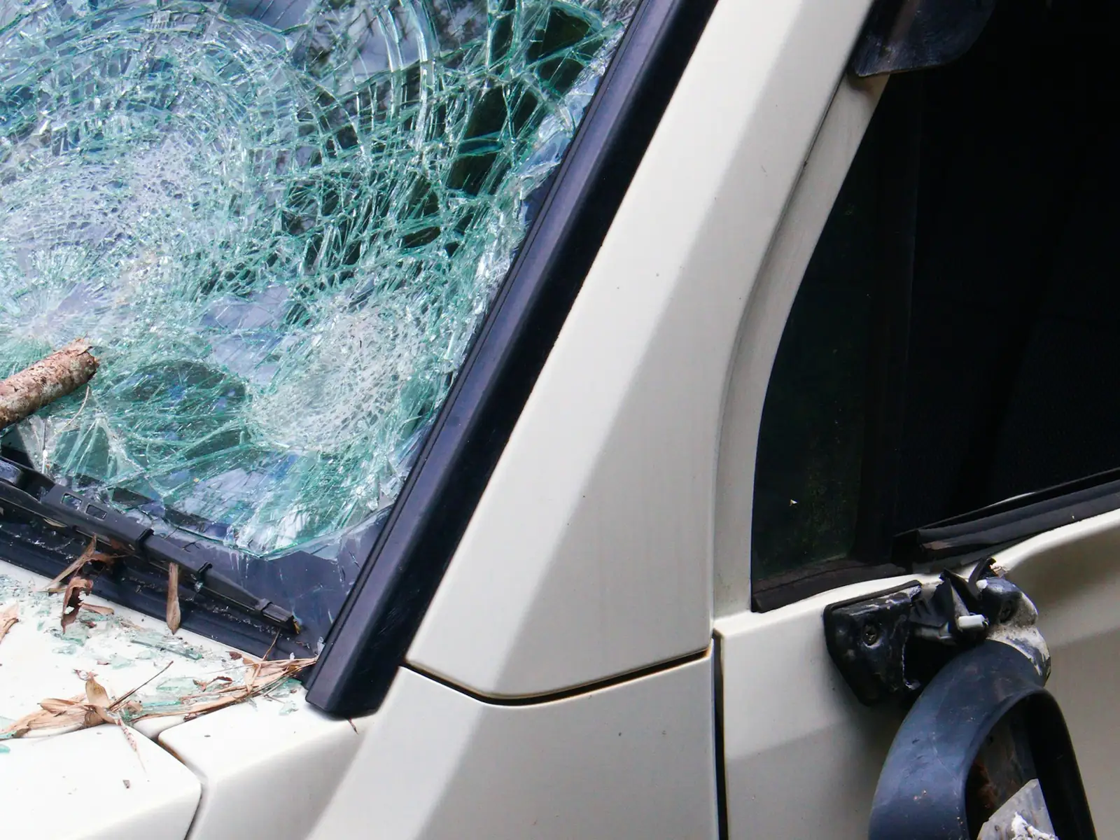 Storm-damaged windshield with a cracked spiderweb pattern